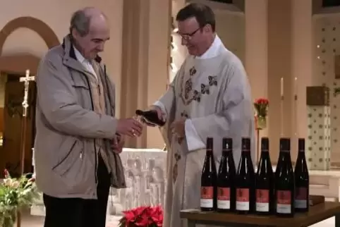 Pfarrer Andreas Rubel schenkt Klaus Graber einen Schluck Johanneswein ein. Diesmal ist es ein Spätburgunder aus dem Hause Stenge