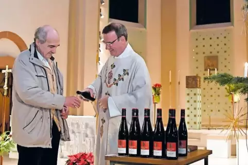 Pfarrer Andreas Rubel schenkt Klaus Graber einen Schluck Johanneswein ein. Diesmal ist es ein Spätburgunder aus dem Hause Stenge