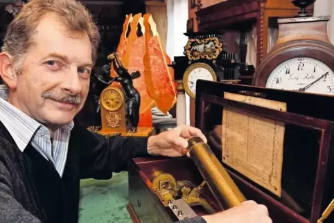 Richard Meng mit seinem antiken Musikautomaten und einer Tonwalze.