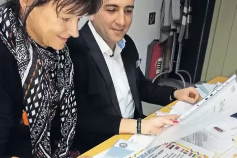 Flüchtling Arsen Avetisyan und Heidi Kirstein-Berger vom BFB Asselheim sehen die Bewerbungsunterlagen durch: Avetisyan hat einen