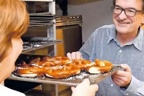 Bäckereiinhaber Horst Hartmut begutachtet die Brezeln, die Christine Zimmermann auf dem Backofen geholt hat.
