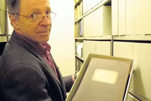 Mittendrin: Dr. Walter Rummel, Leiter des Landesarchivs Speyer, hält einen Teil des Stadtarchivs Landstuhl in Händen.