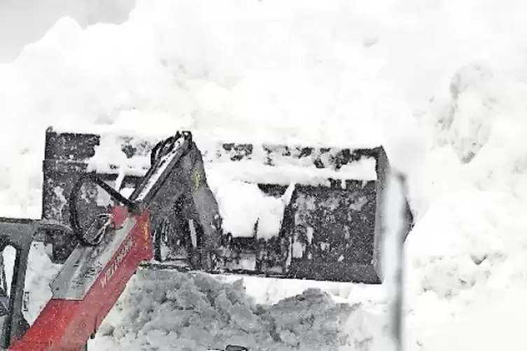 Bagger räumen die Schneemassen von einer Straße im österreichischen Niedertauern.