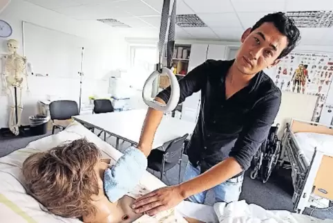 Modellprojekt mit Übungspuppe: Ein Flüchtling wird zum Altenpfleger ausgebildet.