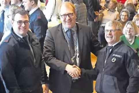 Torsten Bechtel gratuliert Fabian Geibel (links) beim Neujahrsempfang zur Beförderung zum Hauptfeuerwehrmann sowie Ralf Johannse