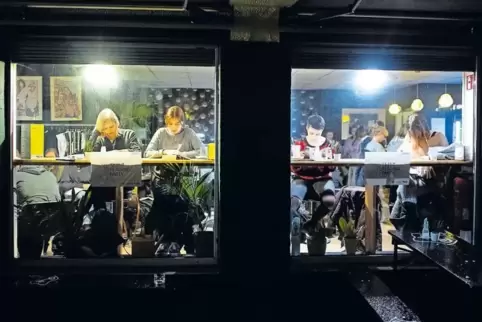Wer im Glashaus sitzt, liest besser: Teilnehmer einer gemeinsamen stillen Leseparty („Silent Reading Party“) in Osnabrück. Still