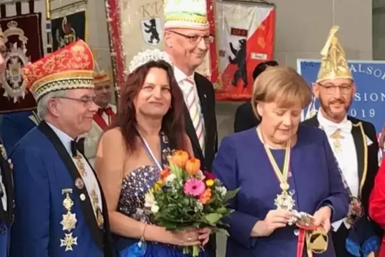 Kanzlerin Merkel begutachtet den Orden von Silke I. und Ingo I. (rechts). Mit dabei: Jürgen Lesmeister (links) und Andreas Müss 