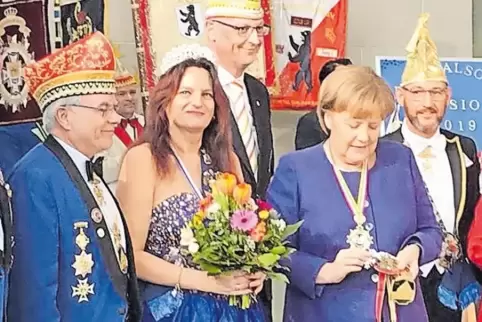 Kanzlerin Merkel begutachtet den Orden von Silke I. und Ingo I. (rechts). Mit dabei: Jürgen Lesmeister (links) und Andreas Müss 