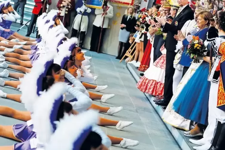 Spagat f&uuml;r das Staatsoberhaupt: Angela Merkel applaudiert den Tanzmariechen einer Prinzengarde.