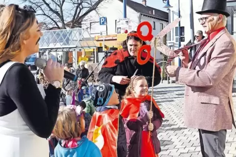 Rathaus-Vorplatz Dudenhofen: Mit einer gebastelten Schere gehen die Kinder Ortsbürgermeister Peter Eberhard an die Krawatte.