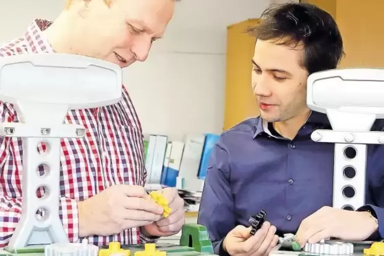 Dominik Klein (rechts) und J&uuml;rgen Munz mit Prototyp und Serienmodell der Bosch-Werkbank.