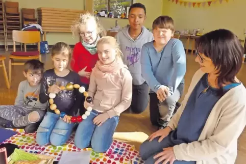 Fasziniert waren die Kinder von der großen Version der „Perlen des Glaubens“, die sie mit Gemeindediakonin Gabi Rathke (rechts) 