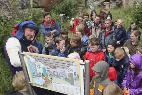 Anschaulicher Geschichtsunterricht: Rolf Übel (links) erklärt in mittelalterlicher Kostümierung Kindern das Leben auf einer Ritt