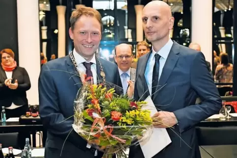 Blumen für den Beigeordneten: Oberbürgermeister Martin Hebich (links) gratuliert Bernd Leidig. Im Hintergrund applaudiert Bürger