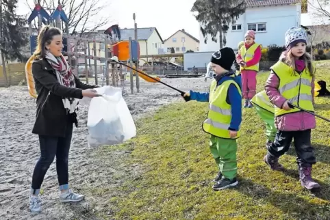 Projektleiterin Antje Bruckert mit ihren Kindern vom Müllprojekt. Hier ist die Gruppe auf einem Spielplatz im Einsatz.