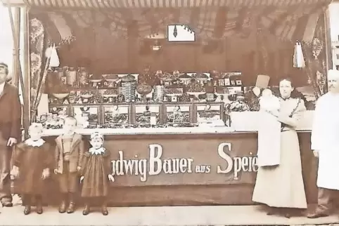 Die Anfänge: Ludwig und Anna Bauer (beide rechts im Bild) vor einem Stand im Jahr 1901. Ihr Sohn Franz (Dritter von links) hat d