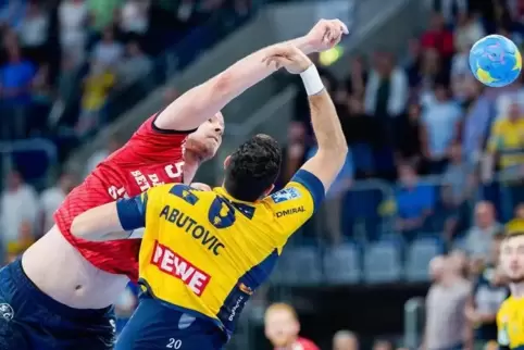 Flensburgs Simon Hald Jensen (l) und Ilija Abutovic von den Rhein-Neckar Löwen kämpfen um den Ball.  Foto: Uwe Anspach/dpa 