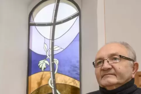 Pfarrer Armand Großmann vor dem von Horst Schwab entworfenen Kirchenfenster.  Foto: m. hoffmann