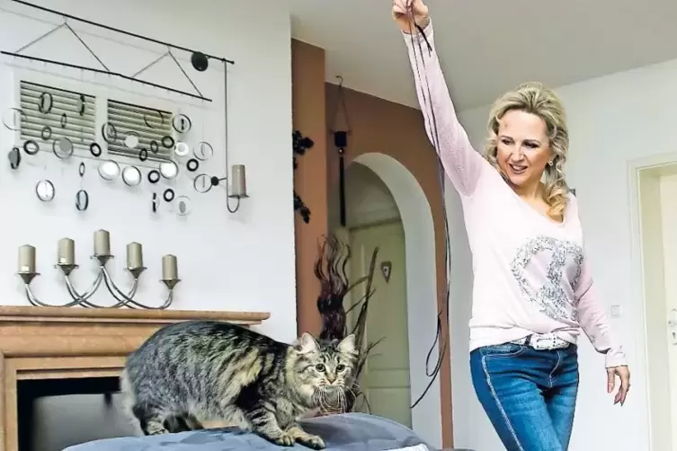 Elena Loch spielt mit ihrer Katzendame Diva.