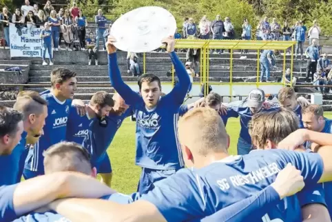 So sehen Sieger aus: Kapitän Fabian Schäfer von der SG Rieschweiler II reckt die zurechtgebastelte Meisterschale in den Himmel. 