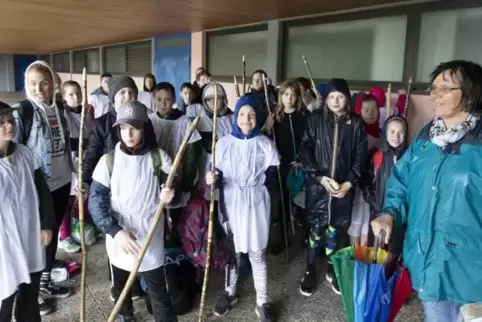 Bevor es zum Speerwurf mit selbst gemachtem Material geht, suchen die Waldorfschüler an der Turnhalle Schutz vorm Regen. Foto: V