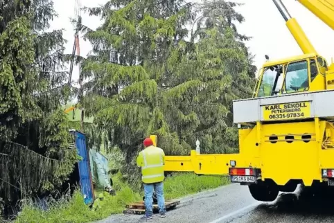 Mit einem Autokran musste der Lastwagen, der hinter den Bäumen in einer Wiese feststeckte, zurück auf die Straße gezogen werden.