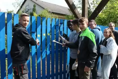 Schüler aus Bad Bergzabern und Jugendliche aus Frankreich verpassen dem Schulzaun einen neuen Anstrich. Foto: Allmann-Stübinger