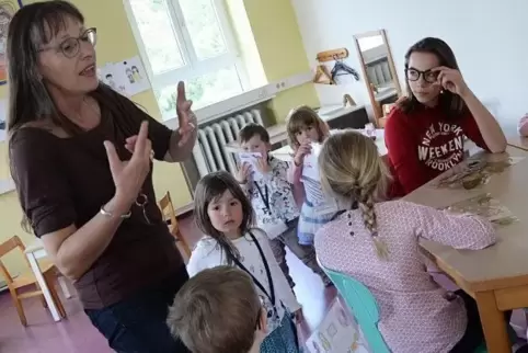 Manou Douillot-Welz, Leiterin der Gruppe „Ile aux Enfants“, erklärt den Kindern den Ablauf des Zwergencafés – natürlich auf Fran