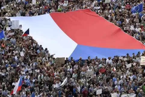 Demonstranten in Prag halten eine große tschechische Flagge bei einem Protest gegen Regierungschef Babis. Foto: dpa