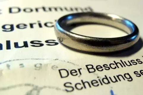 Ein Ehering liegt auf einem Gerichtsbeschluss über eine Scheidung.  Foto: Franz-Peter Tschauner/dpa 