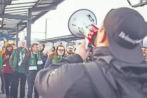 Auf Tour: Flickinger (rechts) sorgt vor einem Auswärtsspiel auf dem Bahnsteig mit dem Megafon für Stimmung bei den Fans.