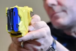Ein Polizist präsentiert einen Taser. Foto: dpa