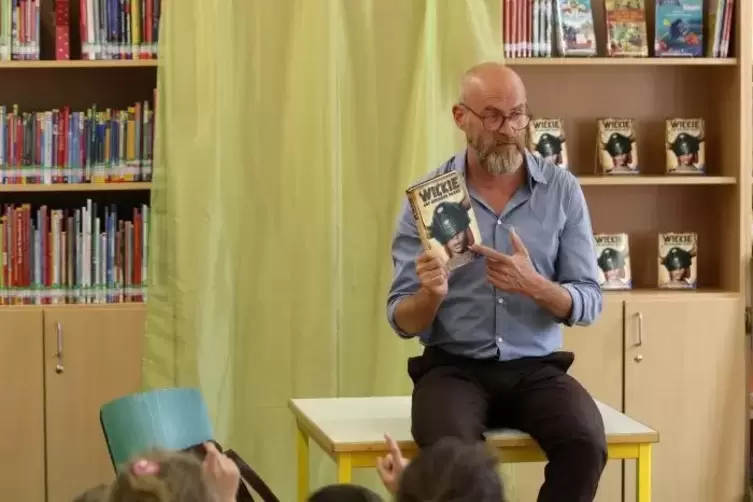 In der Zweibrücker Jugendbücherei setzte sich Thilo Lassak auf den Tisch und las aus seinem Buch zum „Wickie“-Kinofilm.  Foto: t