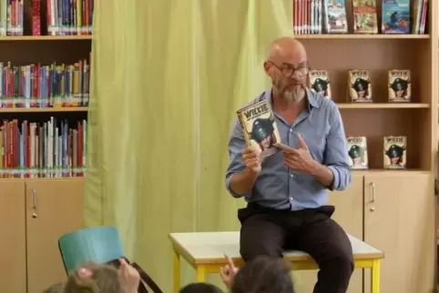 In der Zweibrücker Jugendbücherei setzte sich Thilo Lassak auf den Tisch und las aus seinem Buch zum „Wickie“-Kinofilm.  Foto: t