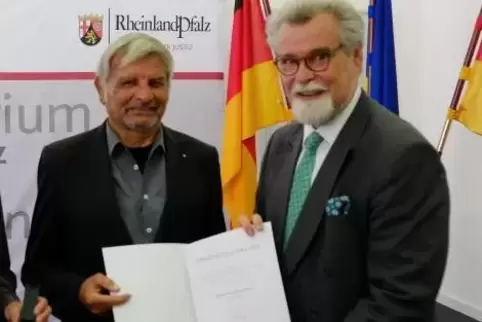 Ausgezeichnet: Ed Kooren (links) hat die Ehrennadel aus den Händen von Justizminister Herbert Mertin erhalten.  Foto: Justizmini
