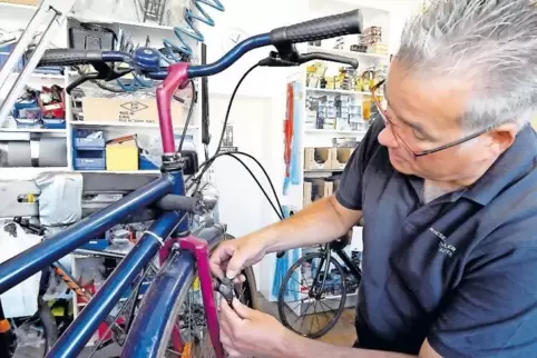 Rainer Maurer prüft Bremsbeläge an einem Fahrrad.