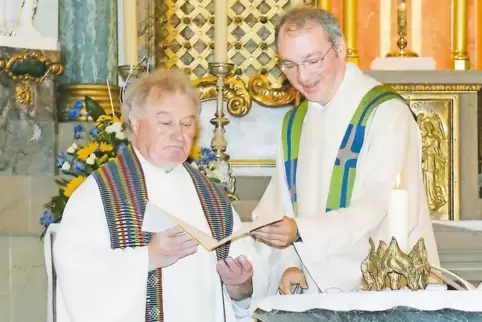 Dekan Markus Horbach (rechts) übergibt Pfarrer Fuhrmann das bischöfliche Dankesschreiben.