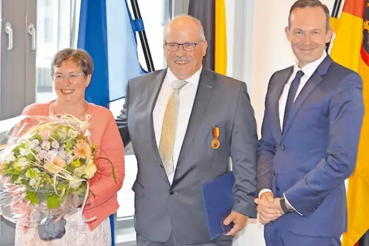Minister Volker Wissing (rechts) überreichte Uwe Bißbort die Verdienstmedaille des Landes. Blumen gab’s für Ehefrau Heike.