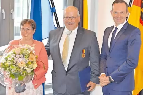Minister Volker Wissing (rechts) überreichte Uwe Bißbort die Verdienstmedaille des Landes. Blumen gab’s für Ehefrau Heike.