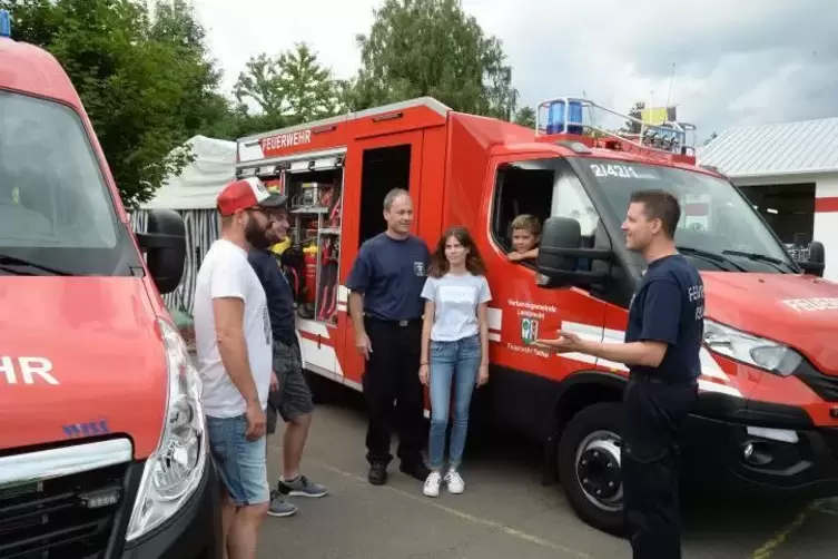 Torsten Buschlinger (rechts) und Andreas Kaiser (Mitte) erklären Besuchern die Ausrüstung der Fahrzeuge. Foto: Linzmeier-Mehn