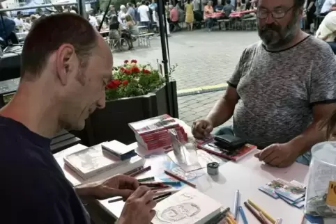 Zeichner Steffen Boiselle (links) fertigte auf dem Kurpfalzplatz Karikaturen von Festgästen an, hier zum Beispiel von Andreas Ba