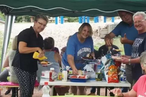 Käshofen grillt und lernt gleichzeitig Englisch mit Jo Anne Pinney (blaues Falcon-Shirt).  Foto: Moschel