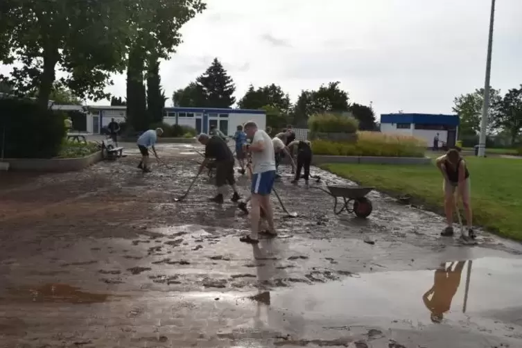 Am Sonntag ab 7.30 Uhr im Einsatz: Rund 50 Ehrenamtliche befreiten das Hambacher Freibad vom Schlamm. Foto: Hocker