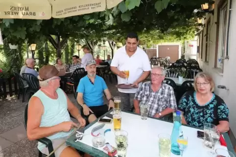 Kleine Oase am Feldrand bei Dudenhofen: Davinder Singh Deol (Mitte), Pächter des „Schwarzen Gockls“, bedient seine Gäste im Bier