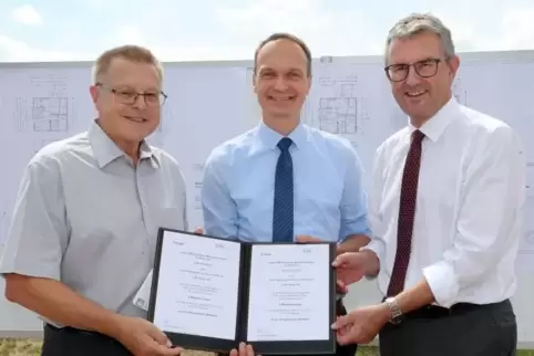 Übergeben den Förderbescheid für den Wohnungsbau in der Neuhofener Straße in Waldsee an Ortsbürgermeister Otto Reiland (links): 
