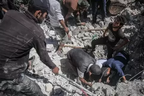Syrische Zivilisten suchen Mitte Juli in der Nähe von Idlib nach Überlebenden nach einem Luftangriff regierungsfreundlicher Kräf