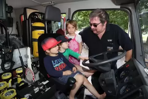 Kindertraum: Odin, Mats und Ronja (von links) dürfen im Feuerwehrauto sitzen, das Feuerwehrmann Claus Ackermann ihnen erklärt. F