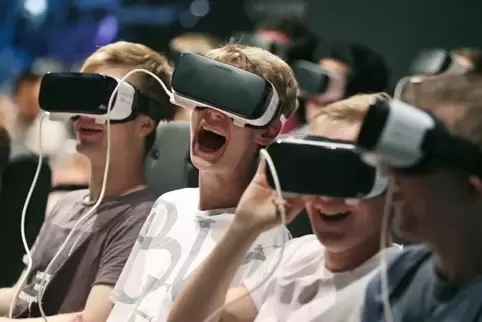Viel Spaß können Computerspiele machen. Und sie können teuer werden. Unser Bild zeigt Besucher einer Branchenmesse mit VR-Brille
