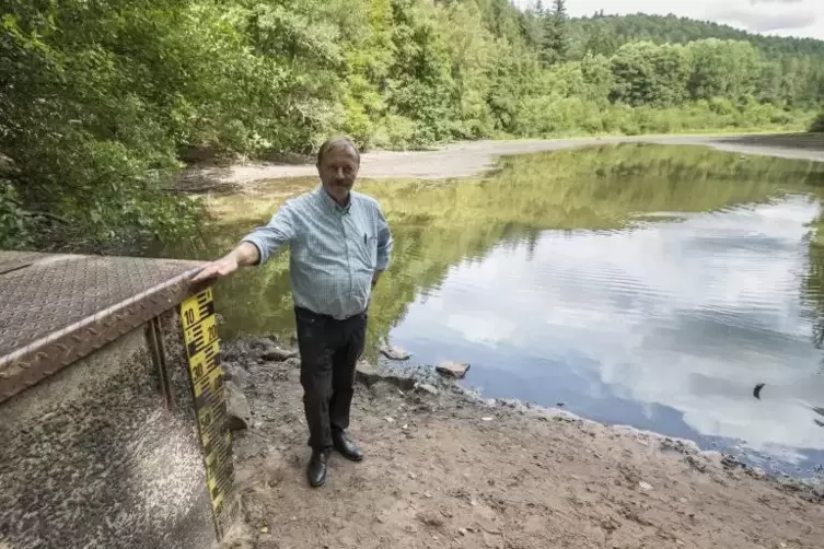Fritz Compter zeigt den eigentlichen Wasserstand des Jagdhausweihers. Derzeit ist das Gewässer eher ein Tümpel – was bei Spazier