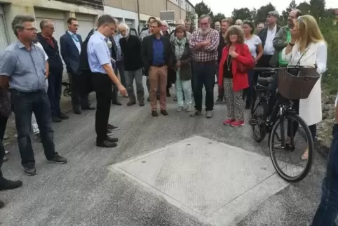 Unter diesem Deckel ist einer der fünf Brunnen: Planer Armin Bender erläuterte das Projekt den interessierten Bürgern. Fotos: ax